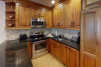 The kitchen in Manor Vail 139 features stainless steel appliances and granite countertops.