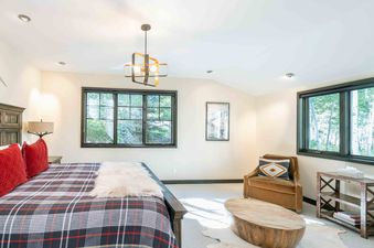 Bedroom interior with plaid bedding, cozy decor, and natural light.
