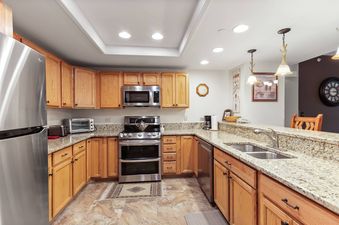 A kitchen with stainless steel appliances, a double oven, and granite countertops.