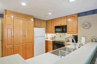 The kitchen in Lodge Tower 594 2 Bedroom features wood cabinets and modern appliances.