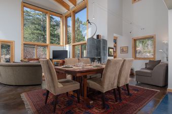 The spacious dining and living area of Westbrook House with large windows showcasing forest views.
