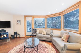 The cozy living area inside Plunge D features comfortable seating and views of the snowy outdoors.