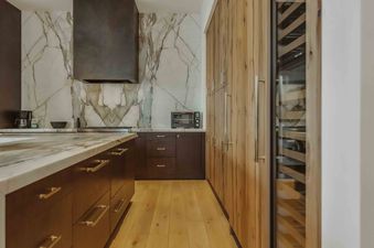 A modern kitchen featuring sleek cabinets, a marble backsplash, and state-of-the-art appliances.