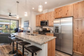 The modern, open-concept kitchen of Arrow Stadthaus with granite countertops and stainless steel appliances.