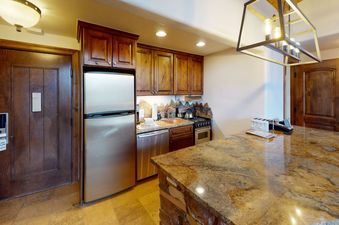 The kitchen in Manor Vail 360 features stainless steel appliances, granite countertops, and a breakfast bar.