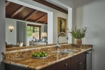 A close-up view of the kitchen in the Montage Flagstaff Suite, showcasing the polished granite countertops, a double stainless steel sink, and a modern chrome faucet.