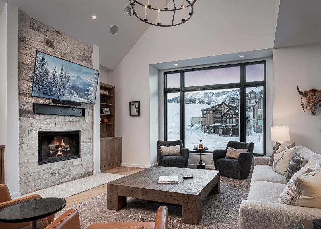 Living area at Spotted Saddle Lodge with stone fireplace and mountain views.