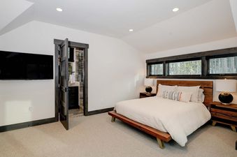 The master bedroom in Moonlight Basin 6 Jakes Lane features a king bed, a large flat screen television and a private en suite bathroom.