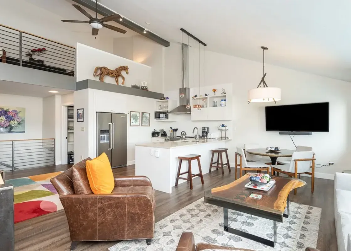 A wide shot of the open-plan living space at Lulu Luxe, featuring a modern kitchen, dining area, and lounge.