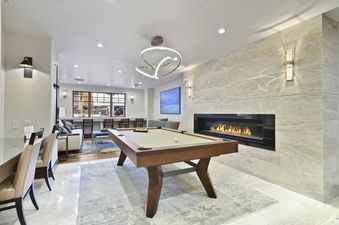 A spacious and modern common area at Silver Strike Lodge 304 features a pool table, a large fireplace, a television, and ample seating.
