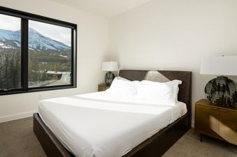 Moonlight Basin 204 Lakelodge bedroom with a king-size bed and a view of the mountains.