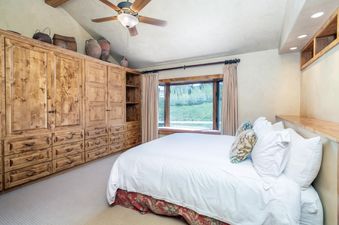 A bedroom in Shirana Penthouse 9 with built-in wooden storage and a plush bed.
