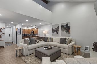 The living room of Snow Flower 078 features a large sectional sofa with pillows and a throw blanket, a coffee table, and an end table.