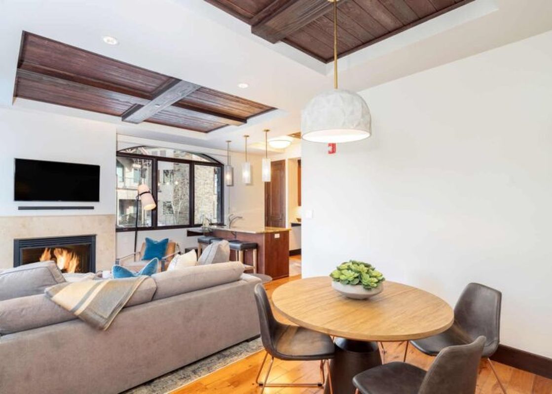 A spacious living area in Lumiere One Bedroom Standard Residence with a fireplace, a couch, and a coffee table in the living area.