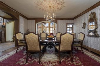 Chalet 67 features a spacious dining room with a large wooden table, comfortable chairs, and a beautiful chandelier.
