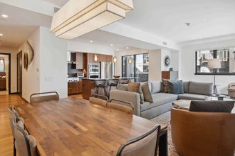 The Lion W302 has a spacious dining area with large windows, a modern kitchen, and a comfortable living area with a couch and chairs.