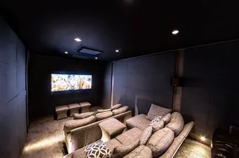 A home theater with comfortable seating, a large screen, and surround sound speakers.