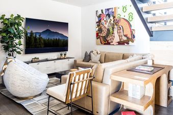 Moonlight Basin 8C Speedwell living room features comfortable seating, a flat-screen TV, and a modern wood and metal coffee table.