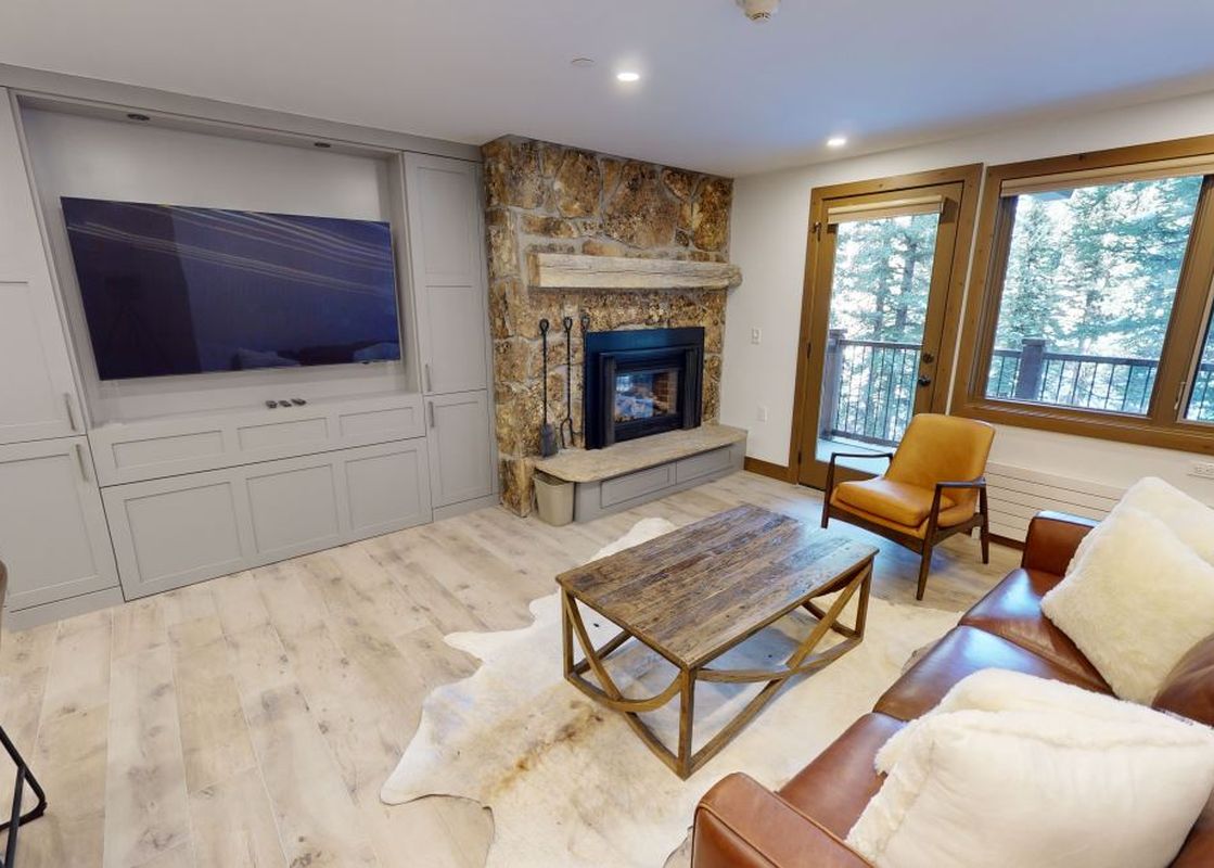 A living room with a fireplace, a large couch and a coffee table.