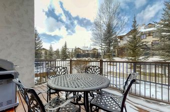 A snow-covered outdoor patio with a table and chairs.