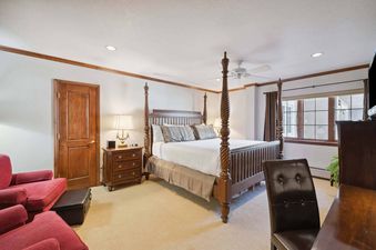 The bedroom at St James Place 218 features a large four-poster bed, a ceiling fan, and a view of the outside through the window.