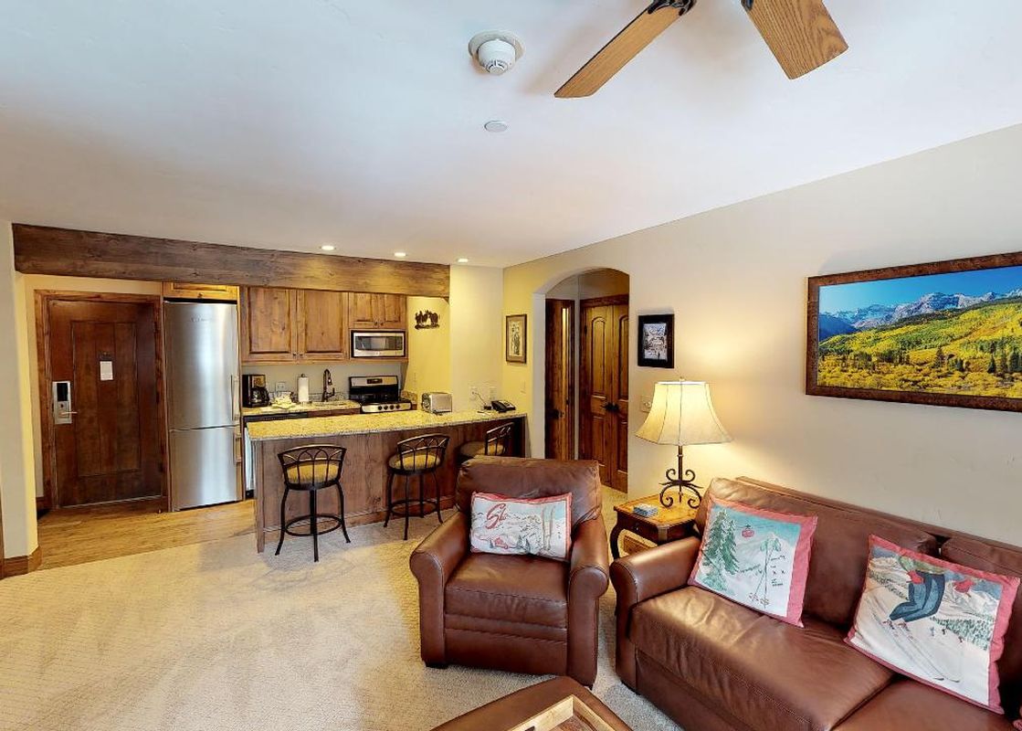 A living room in Manor Vail 267 with a leather couch facing a large flat-screen TV.