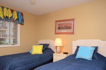 A twin bedroom at Ranch at Steamboat RA304 with two beds, a nightstand, and a window.