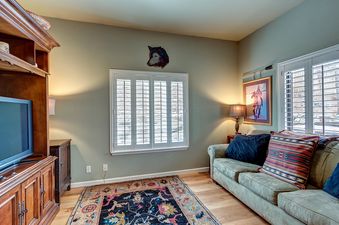 A living room with a couch, a TV, and a rug.