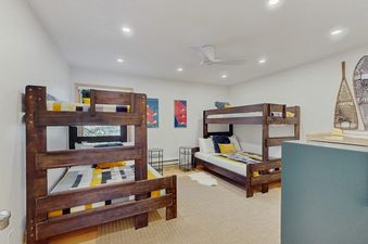 A cozy bunk bedroom in Kutuk 108 with two wooden bunk beds and yellow and grey bedding.