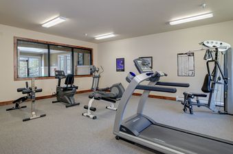 A well-equipped fitness center with various exercise machines, including a treadmill, elliptical, and weight station.