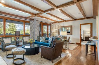 Comfortable living room with wood ceiling beams and large windows in 304C Bear Paw Lodge.