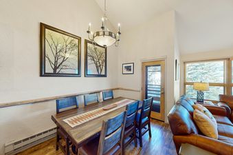 Dining table and chairs in the condo with a view from the window