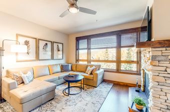 A cozy living room with a sectional sofa, a coffee table, and a fireplace.
