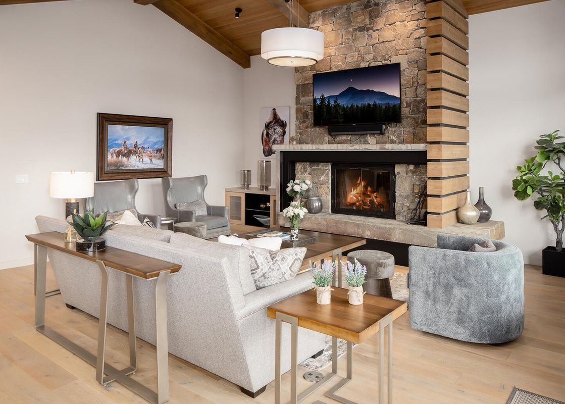 A luxurious living room featuring a large, comfortable sectional sofa, a fireplace, and a stunning view from the window.