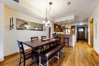 A dining room with a wooden table, chairs, and a bench.