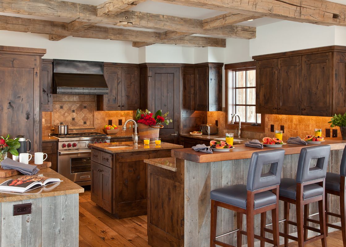 Gourmet kitchen in Shooting Star Cabin 04 featuring dark wood cabinetry, exposed ceiling beams, a central island, and a breakfast bar with seating.