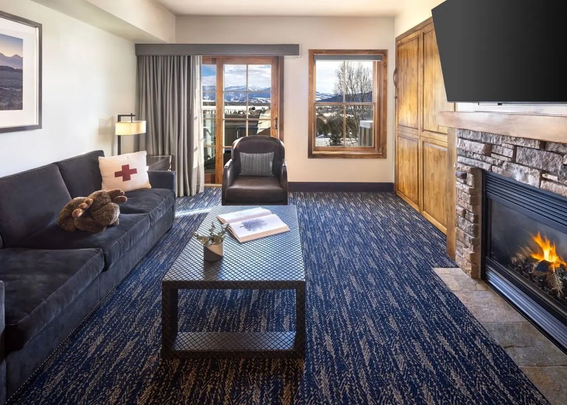Living room with fireplace and mountain view in the Teton Mountain Lodge and Spa One Bedroom Suite.