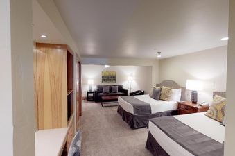 Manor Vail 121, a two-bedroom condo in Vail, Colorado, features a large living room with a sleeper sofa, a dining table, and a fully equipped kitchen.  The condo has two bedrooms with king-size beds. This image shows the master bedroom of the unit.