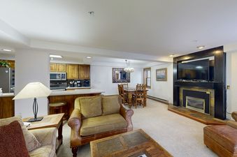 The open concept living area of Torian Plum Plaza 202 is shown, featuring a spacious living room, dining area, and kitchen.