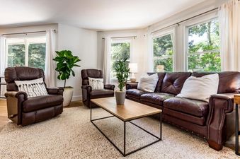 The living room in Abode at Loose Moose features leather furnishings and large windows.