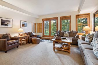 A living room with a large sectional sofa, two armchairs, a coffee table, and an ottoman.