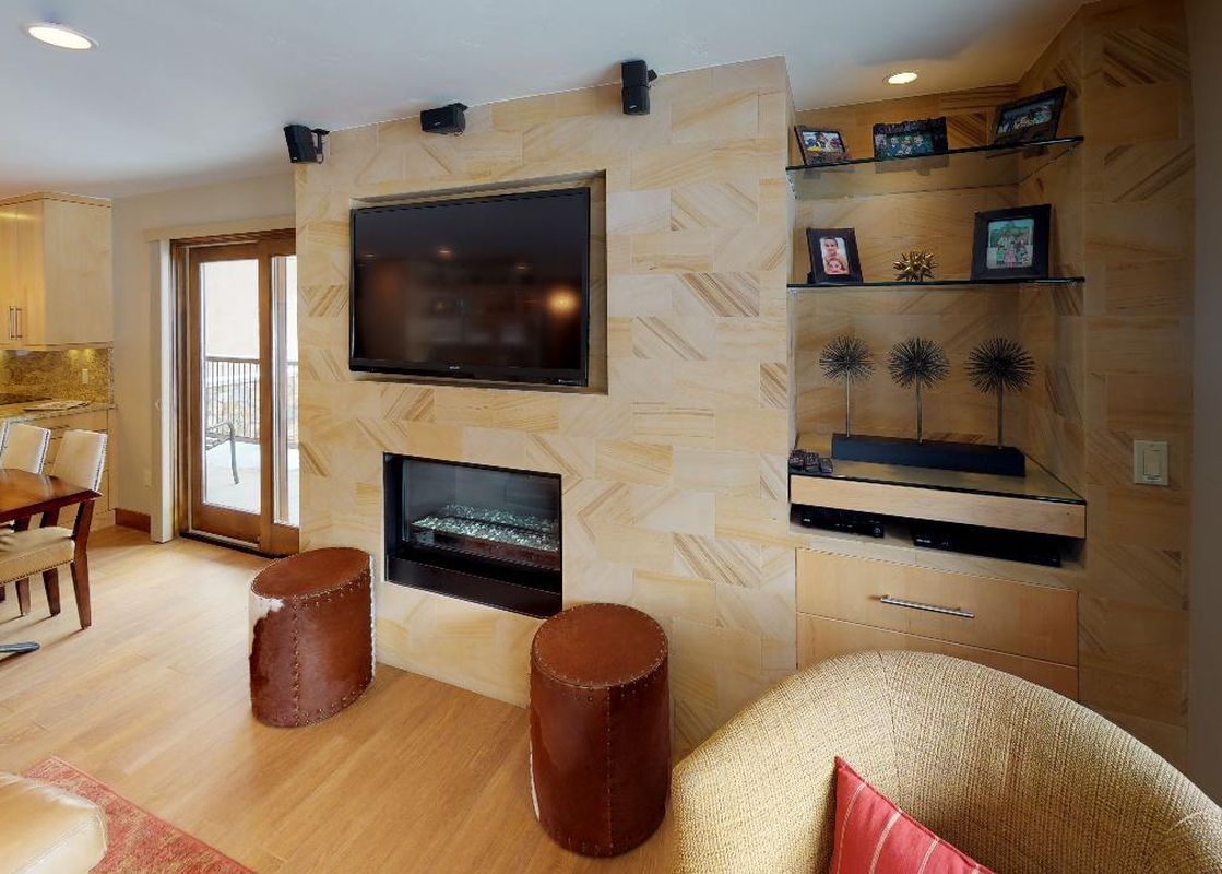 The living room at Manor Vail 254 boasts a fireplace, large flat screen TV, and comfortable seating.