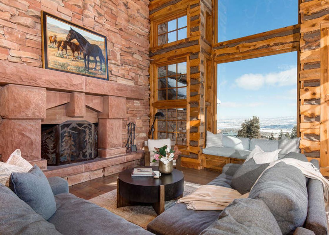 The Treehouse in Canyons Village living room features a large sectional sofa, fireplace, large windows, and views.