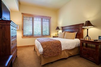 The bedroom in Bear Lodge BL6304 features a queen bed, bedside table, and window.