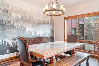 Dining table and chairs inside Trademark Views next to a large window.