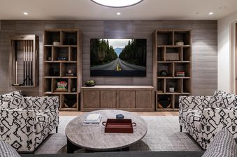 The lower level game room at Moonlight Basin 5 Thistle Way features a large flat screen TV, a comfortable seating area, and built-in shelves.