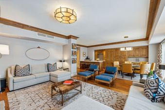 A spacious and inviting living area in the St Regis Executive Suite, featuring comfortable seating, a dining area, and a fully equipped kitchen.