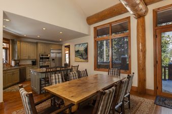 The open-plan kitchen and dining area in Beavers Lodge at River Ridge features natural wood accents and large windows.