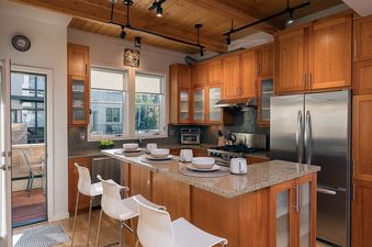 Modern wood-paneled kitchen with stainless steel appliances and a central island at Hawks View Chalet.