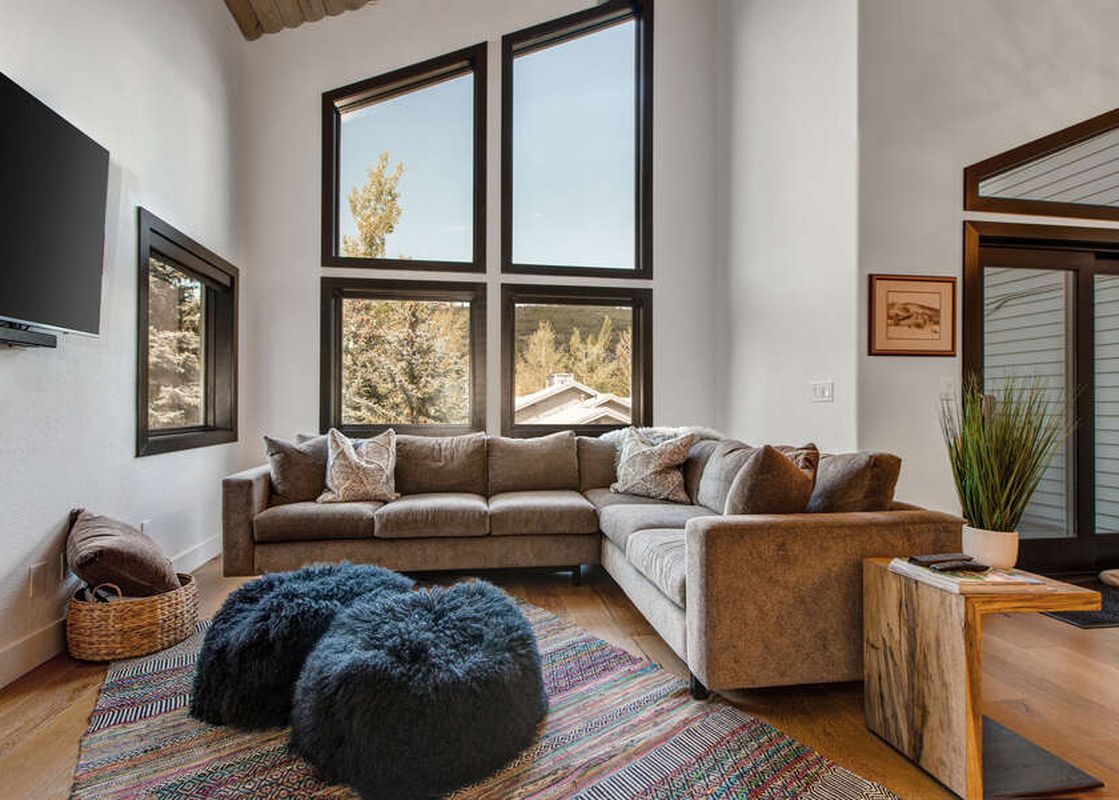 Living room area at Abode in Snow Park with plush seating and outdoor views.